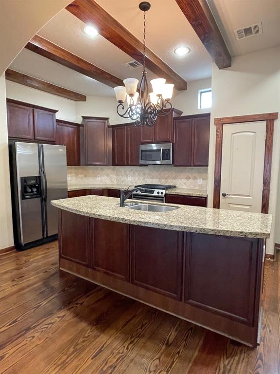 a kitchen with stainless steel appliances granite countertop a sink refrigerator and microwave