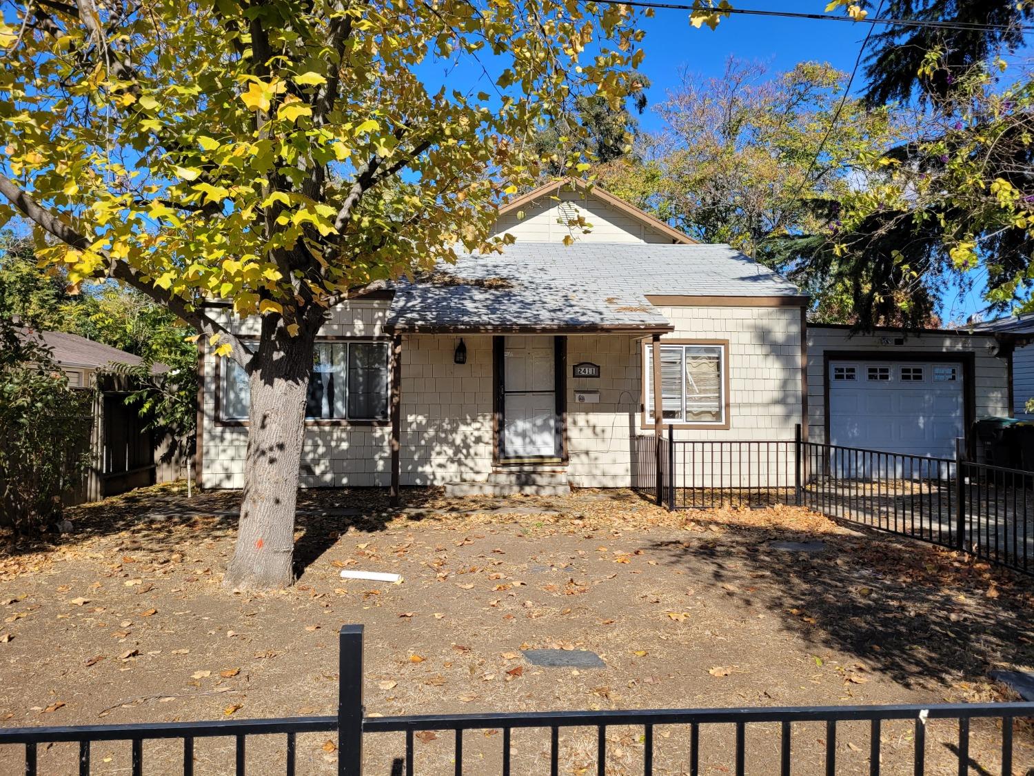 a front view of a house with a tree