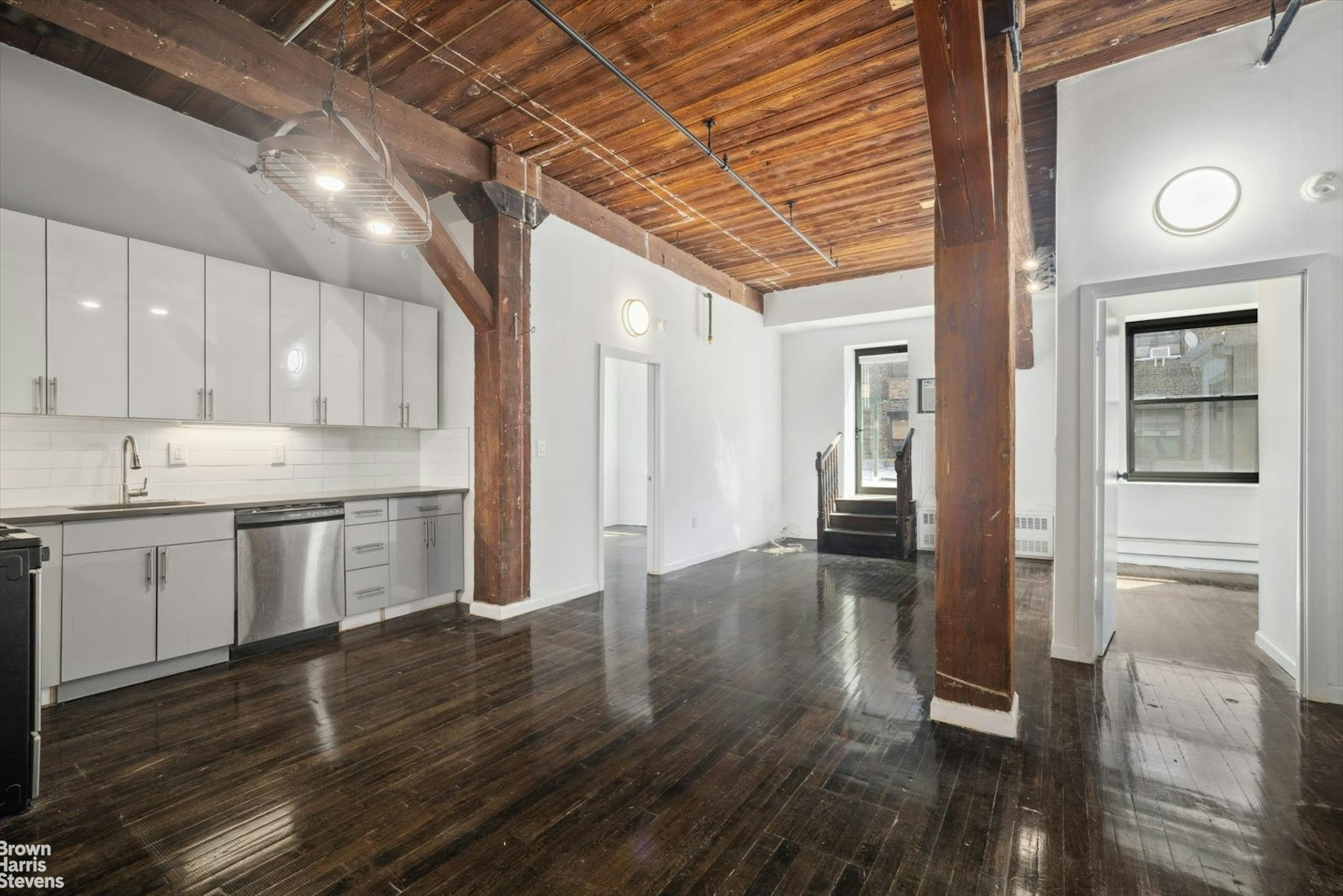 a kitchen with a refrigerator and wooden floor