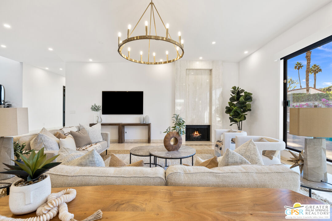 a living room with furniture a potted plant and a flat screen tv