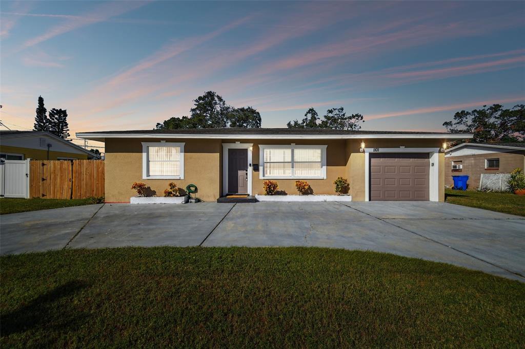 a front view of a house with a yard and a garage