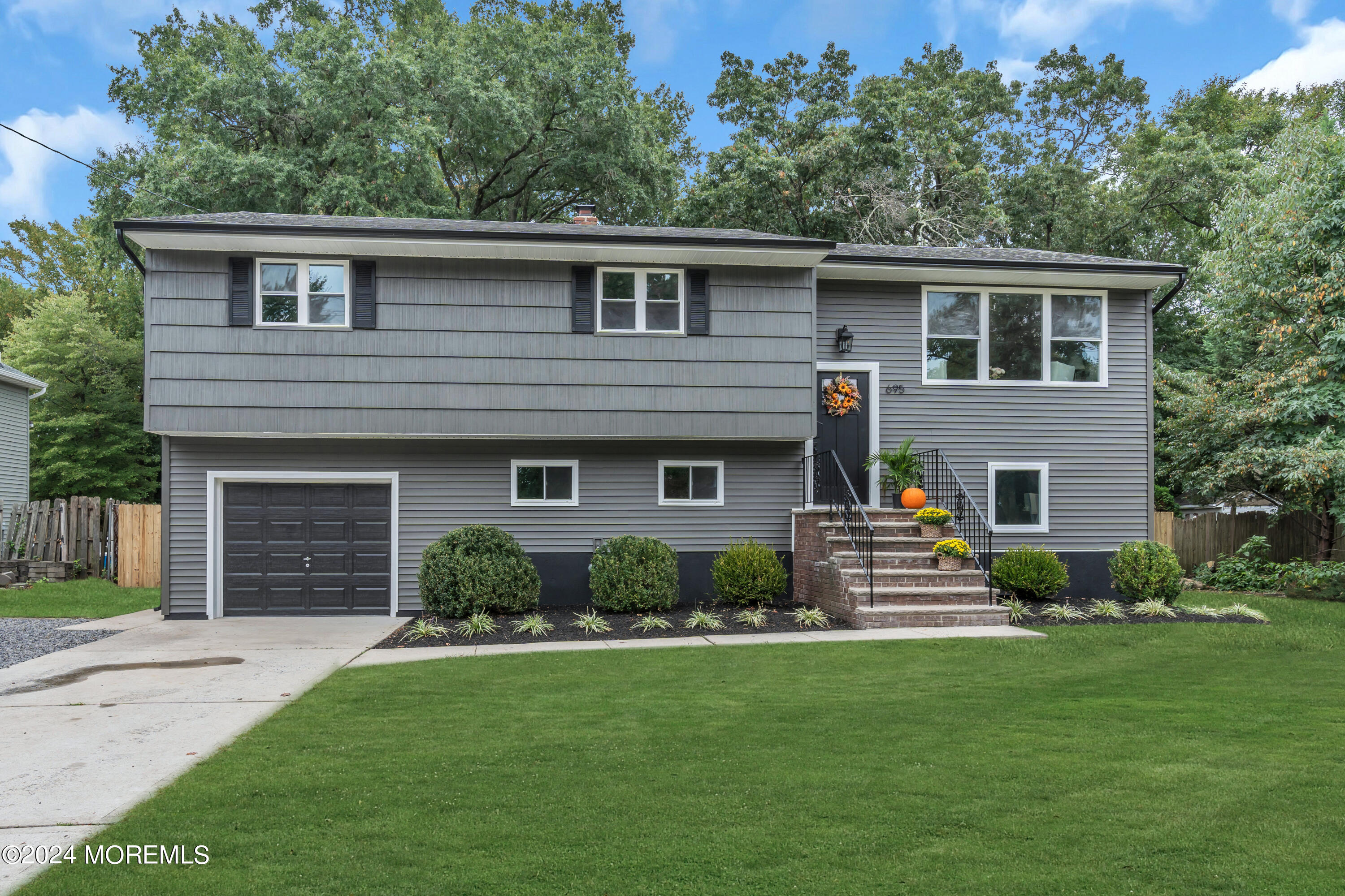 a front view of a house with a garden and yard