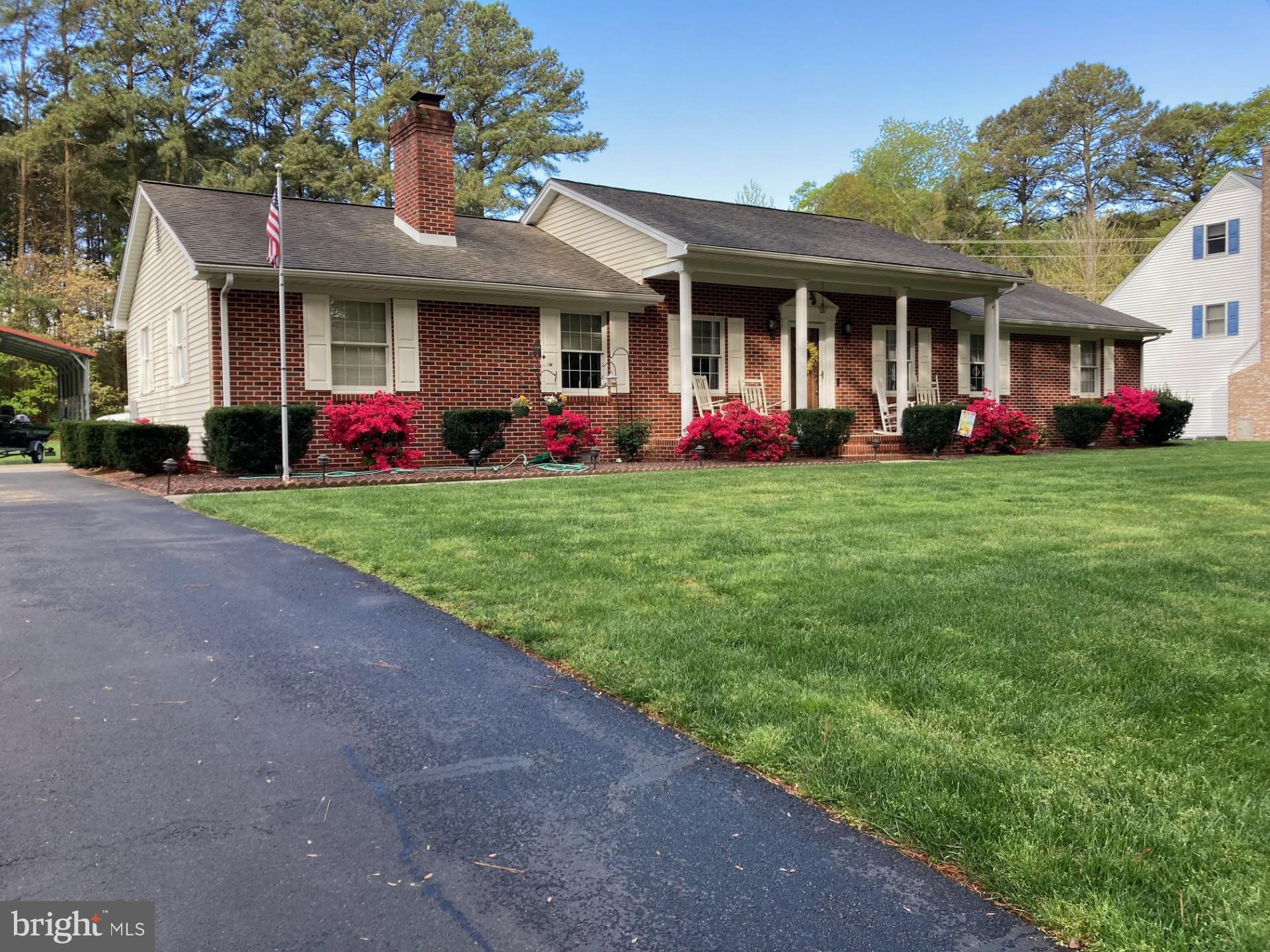 a view of a house with a big yard and large tree