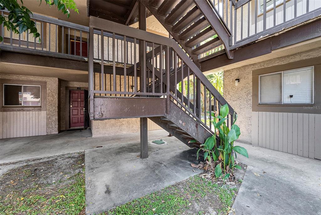 a view of an entryway with a flower garden and stairs