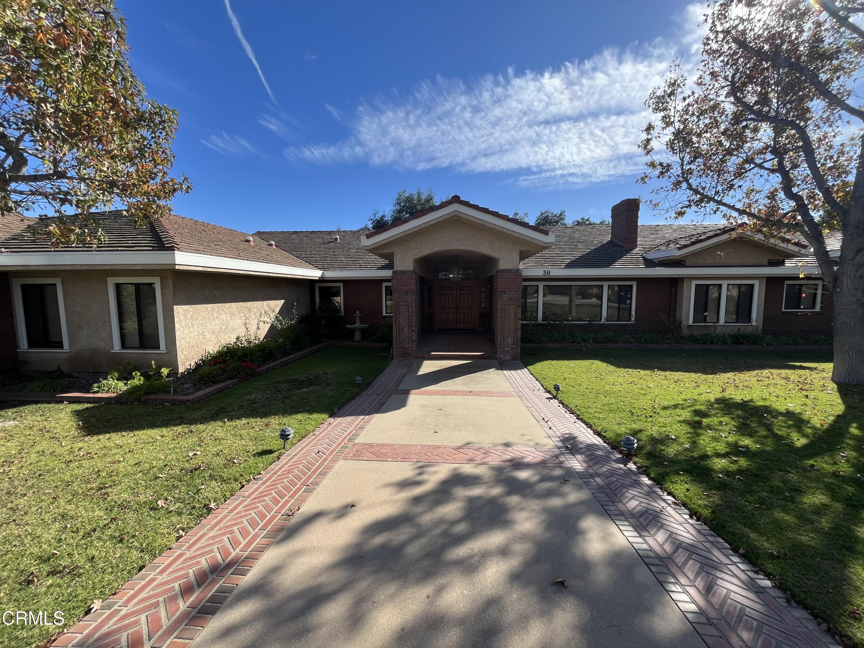 a front view of a house with a garden and yard