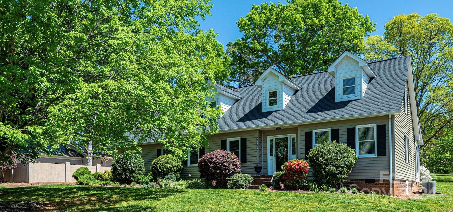 a front view of a house with a garden and plants