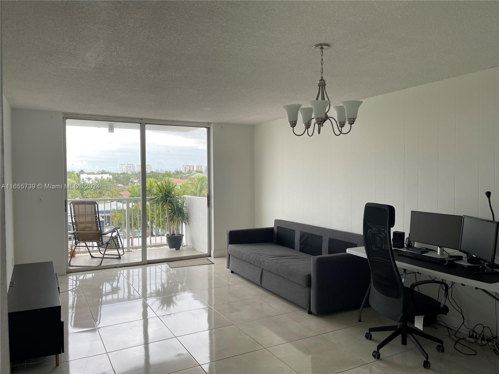 a living room with furniture and a floor to ceiling window