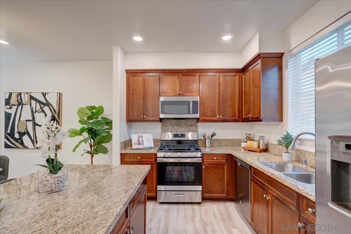 a kitchen with granite countertop a stove a sink and a microwave