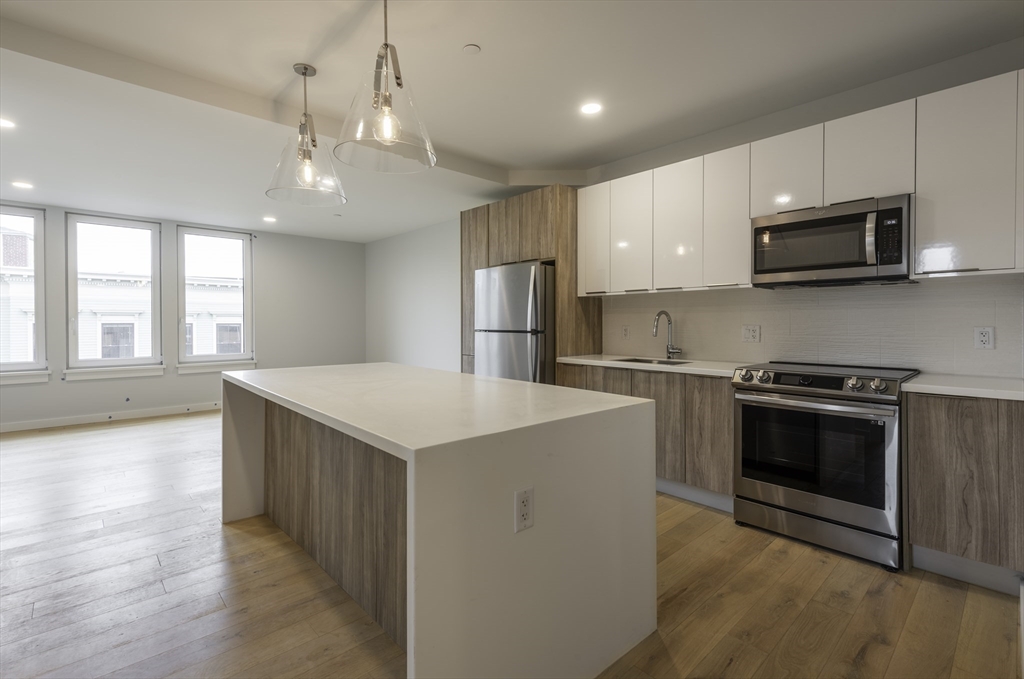 a kitchen with stainless steel appliances a stove top oven a sink and a refrigerator