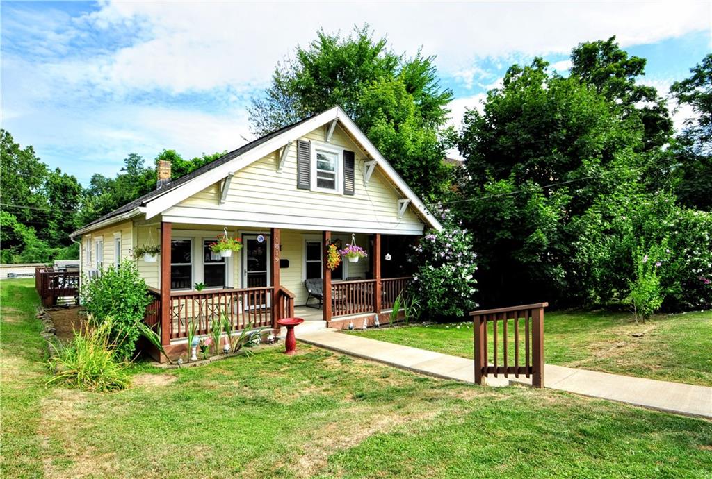 a front view of house with a garden and trees