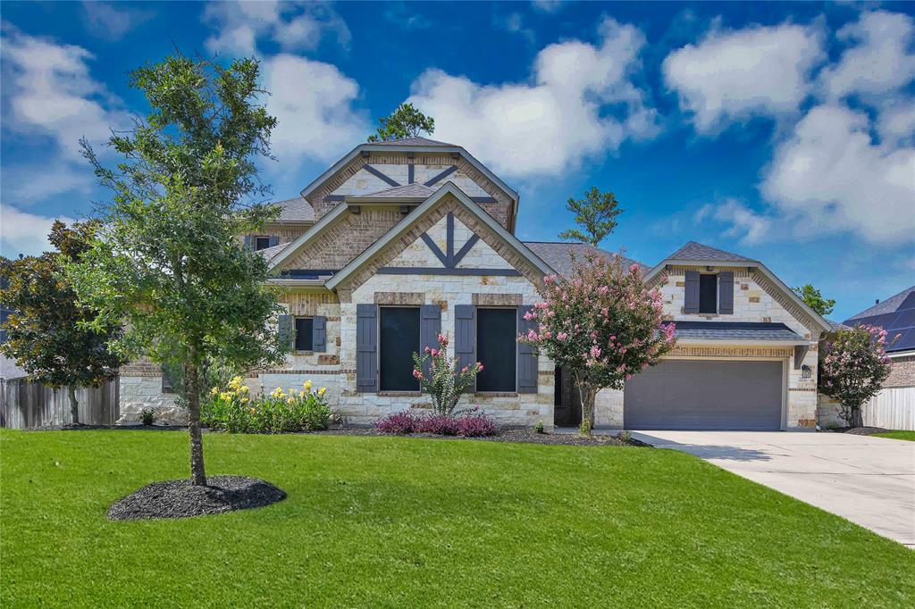 a front view of a house with a yard and a tree