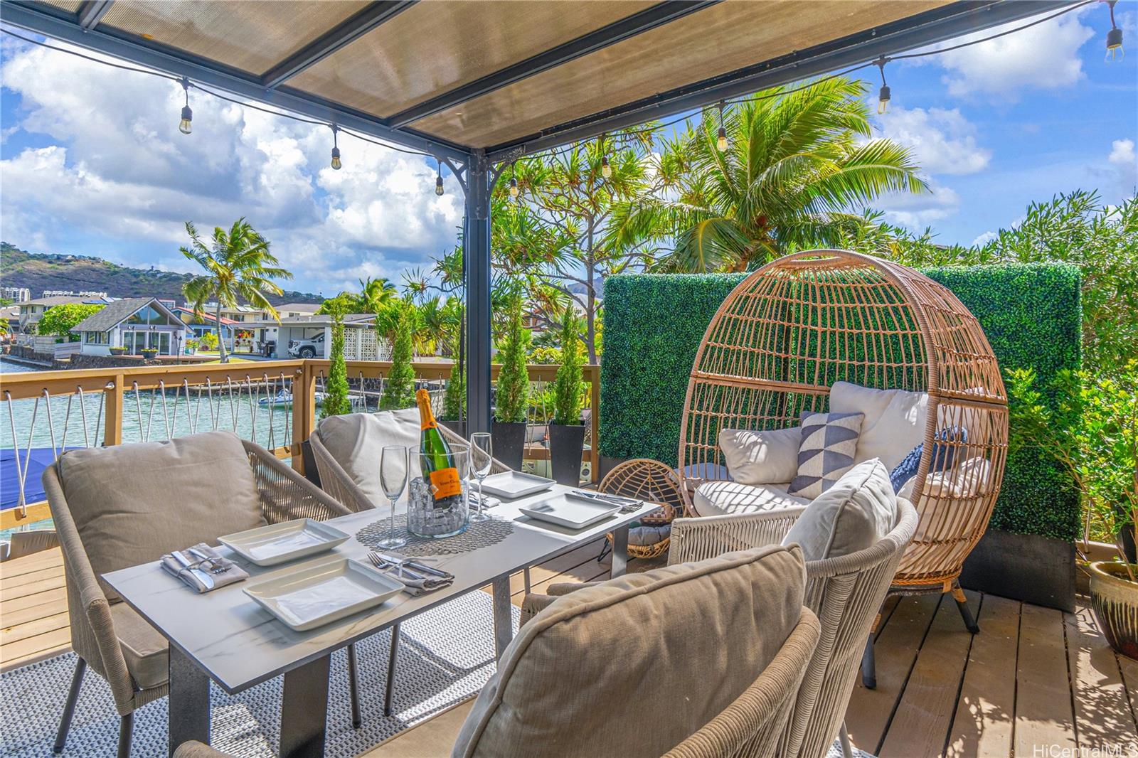 a view of a patio with table and chairs potted plants with wooden floor and fence