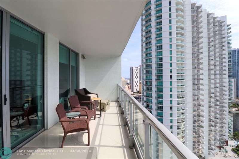 a balcony view with couple of chairs and wooden floor