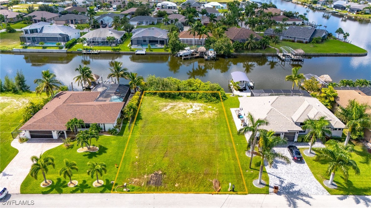 an aerial view of residential houses with outdoor space and lake view