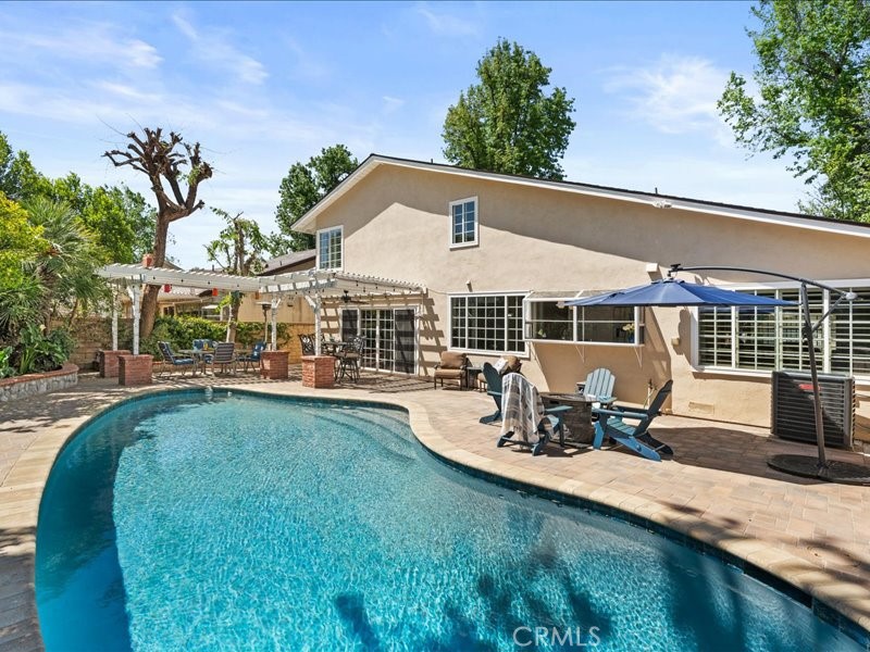 a view of a house with swimming pool and sitting area