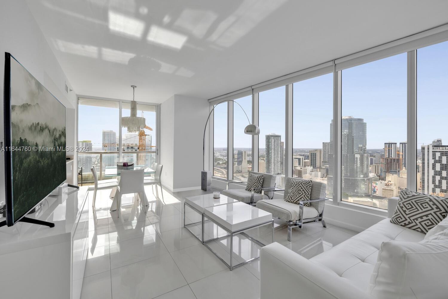 a living room with furniture and a floor to ceiling window