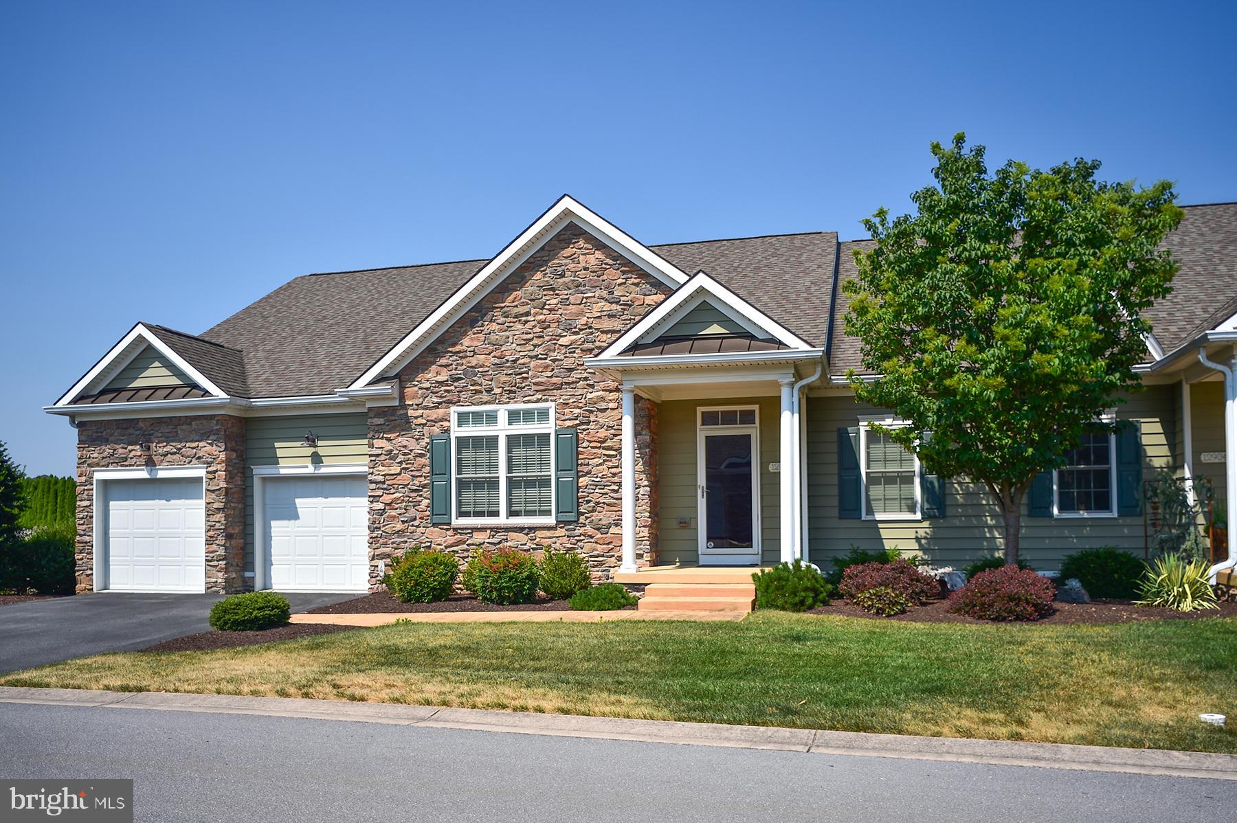 a front view of a house with a garden and yard