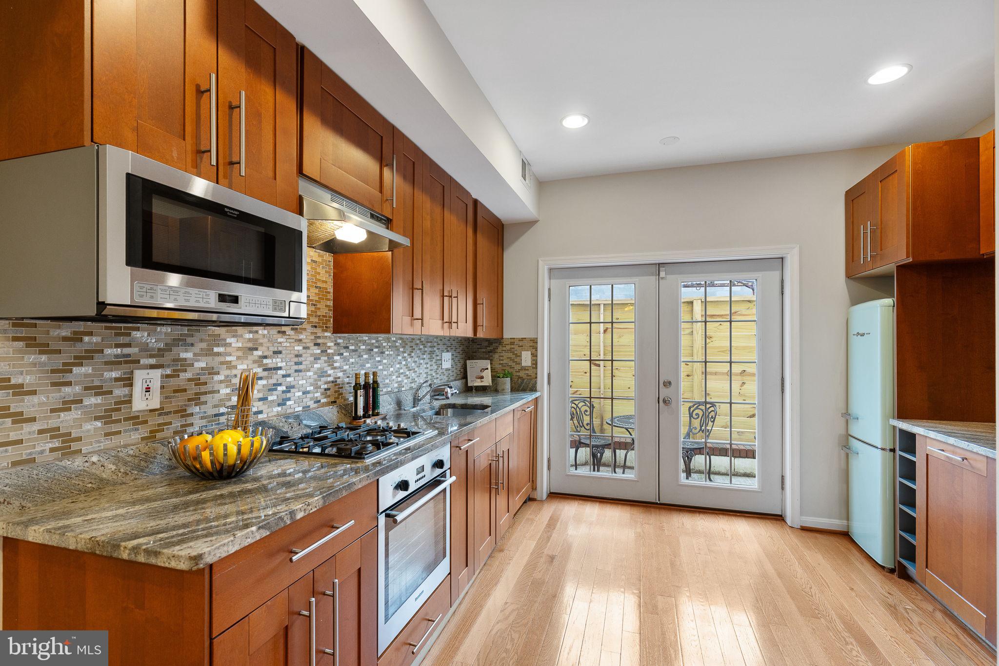 a kitchen with stainless steel appliances granite countertop a stove a sink and a microwave