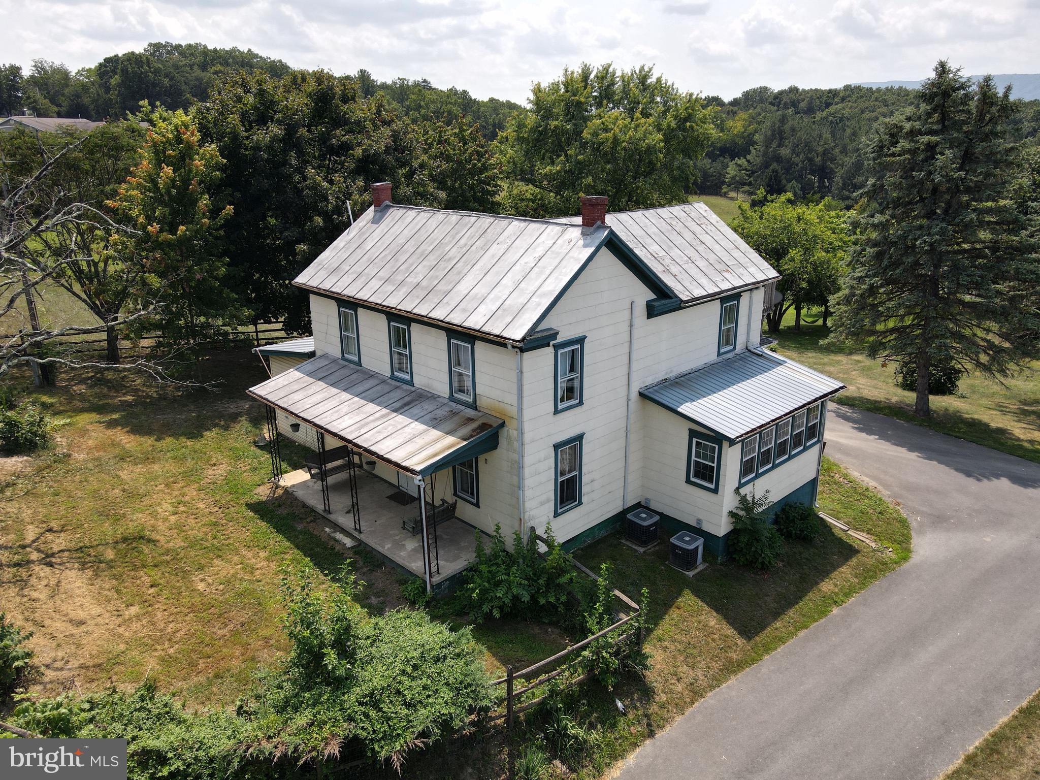 an aerial view of a house with a big yard with large trees