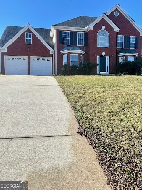 a front view of a house with a yard and garage