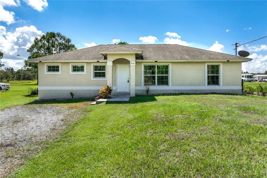 Ranch-style house featuring a front lawn