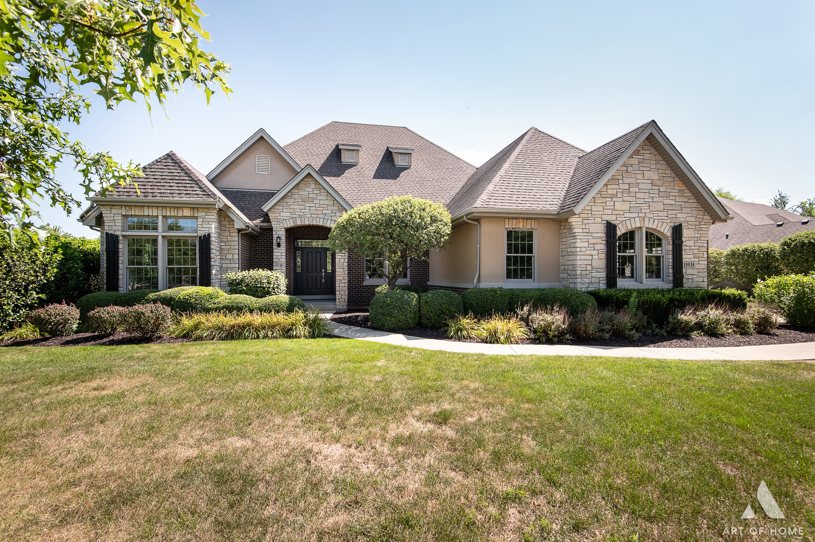 a front view of a house with a big yard and potted plants