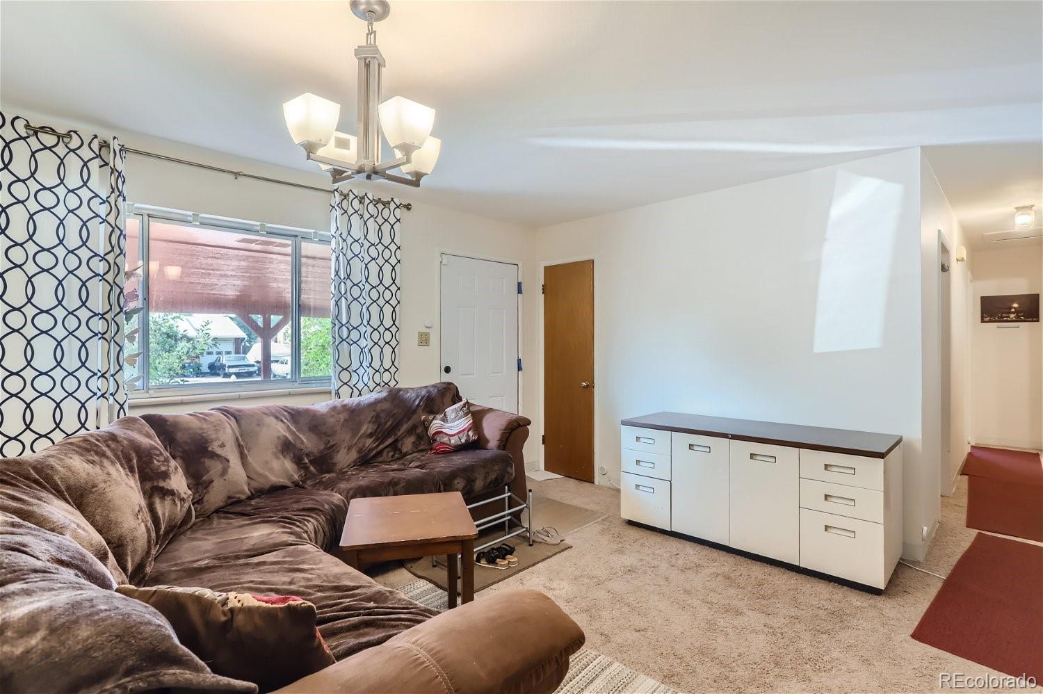 a living room with furniture and a chandelier