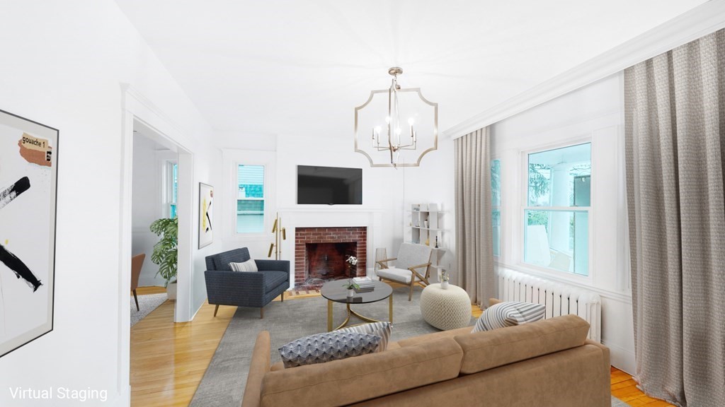 a living room with furniture a fireplace and a chandelier