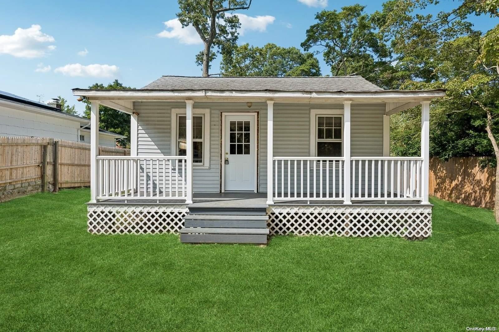 a view of a house with a small yard and wooden fence