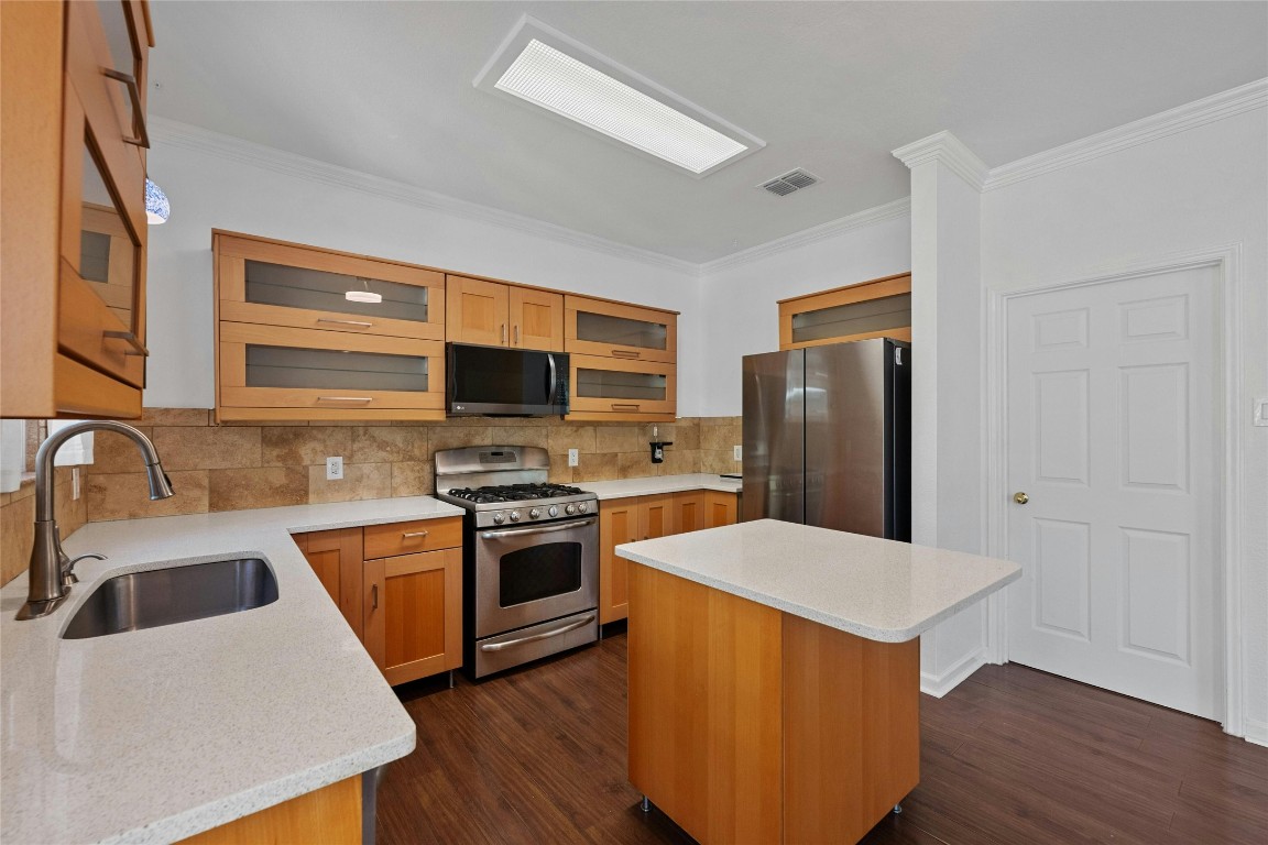 a kitchen with stainless steel appliances granite countertop a sink stove and refrigerator