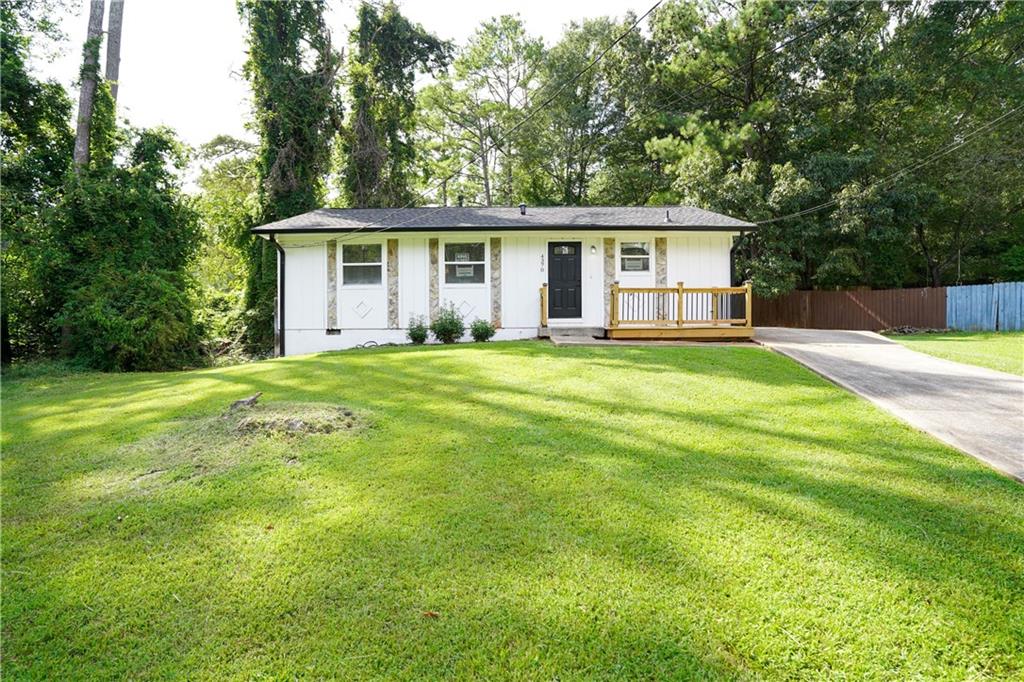 a view of a house with a big yard and large trees