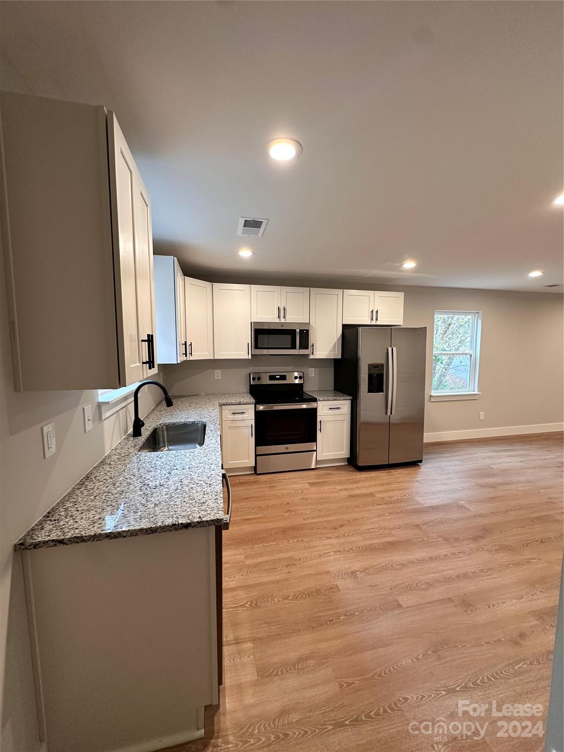 a kitchen with stainless steel appliances granite countertop a sink and a stove