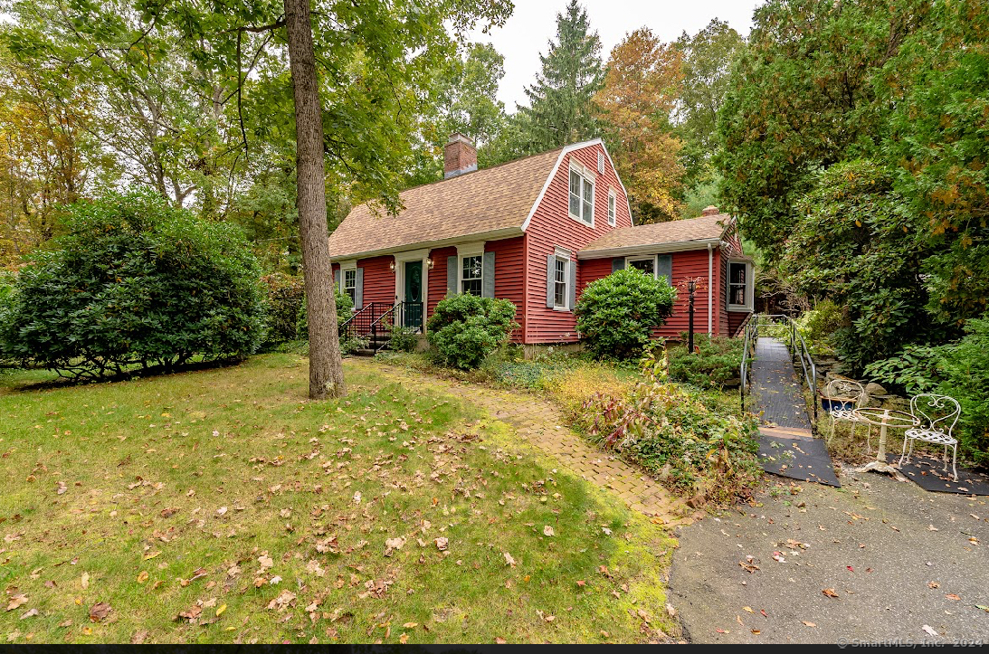 a front view of house with yard and trees around