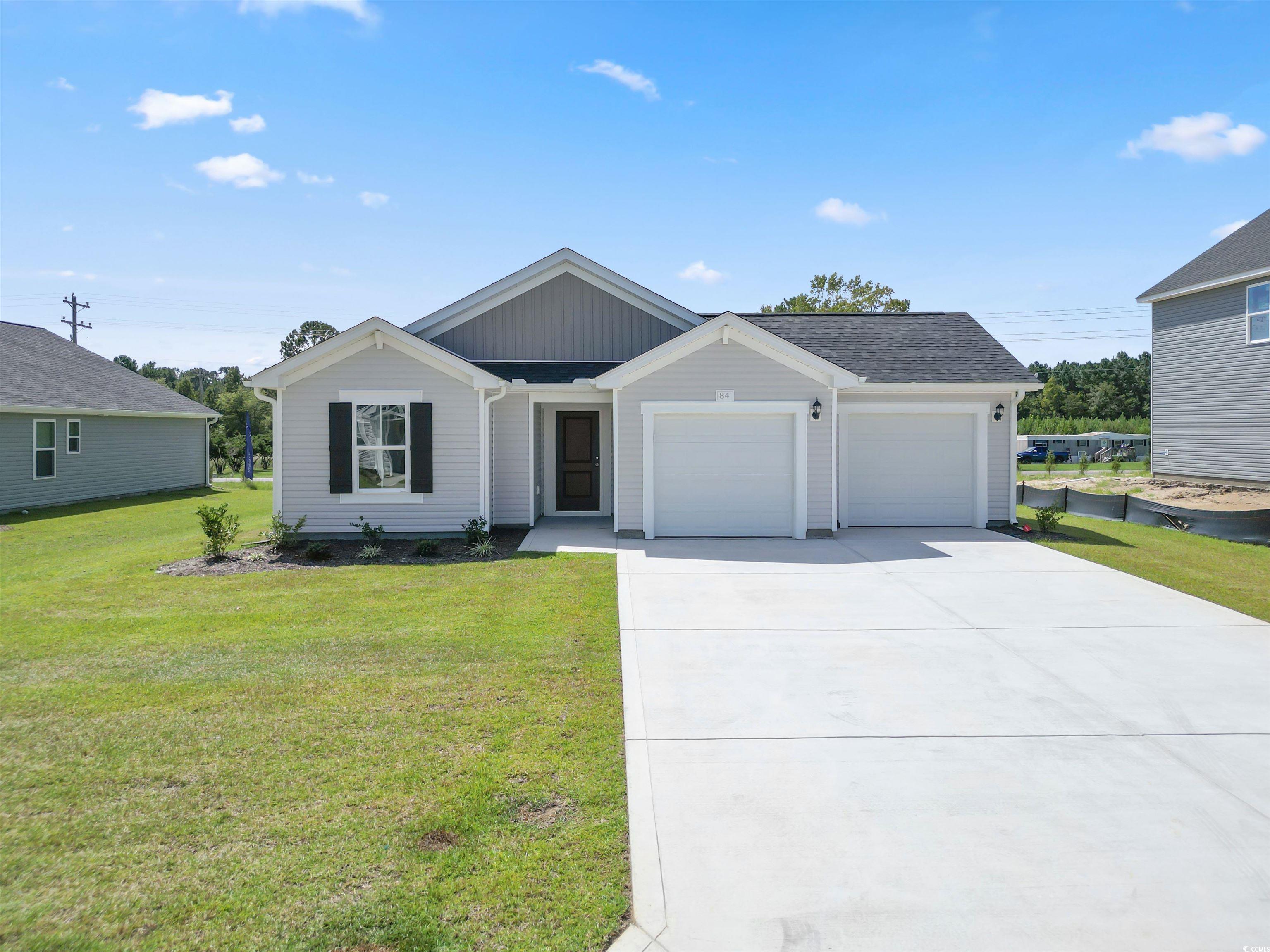 Single story home with a garage and a front yard