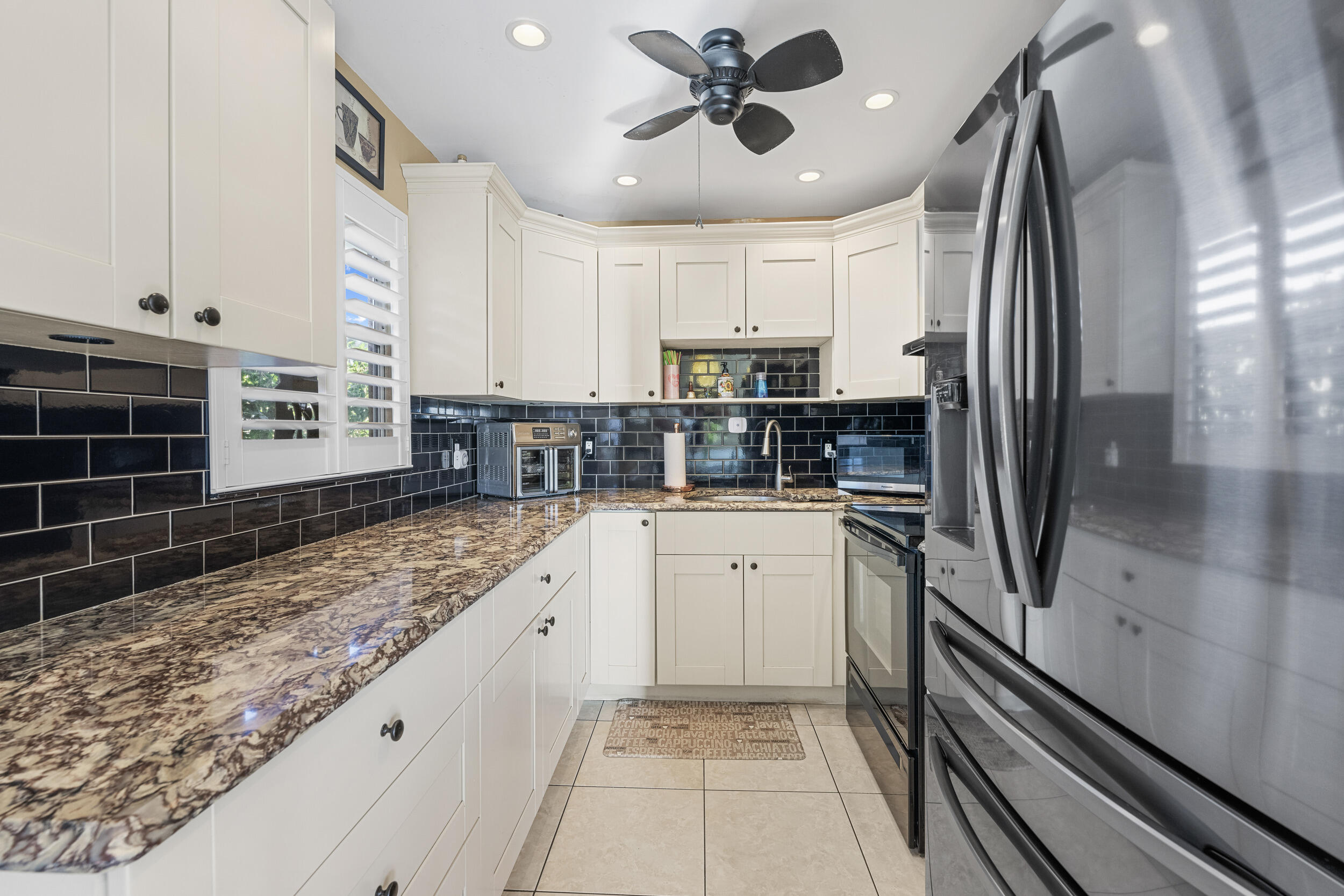 a kitchen with stainless steel appliances granite countertop a refrigerator and a sink