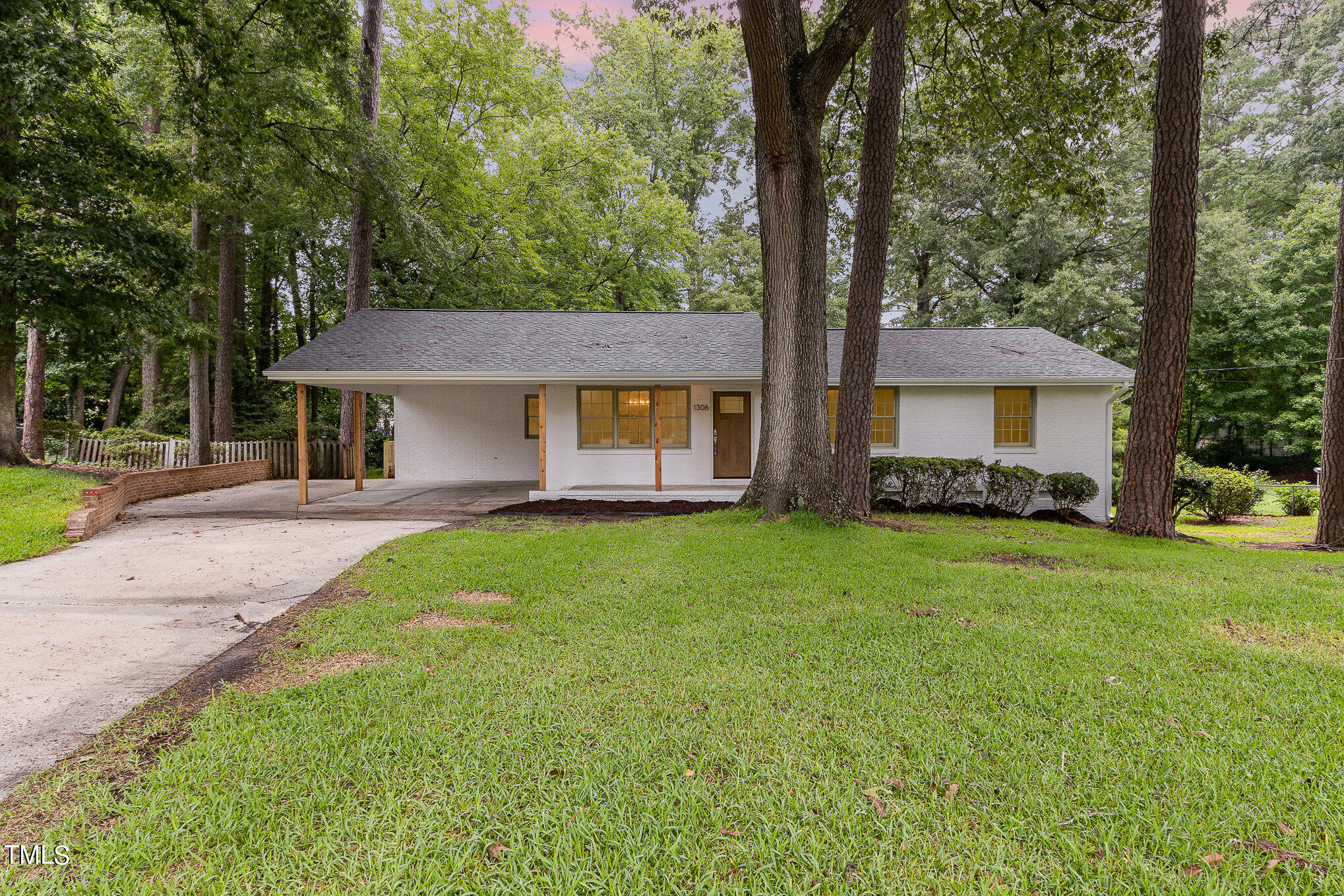 a front view of a house with a garden and yard