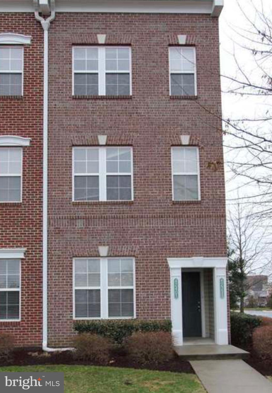 a front view of a brick house with a yard