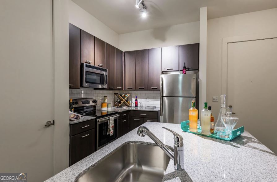 a kitchen with a sink refrigerator and microwave