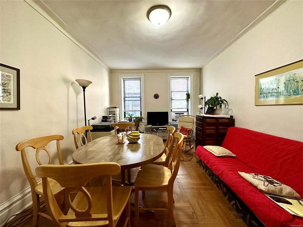 Dining space featuring dark parquet floors and crown molding