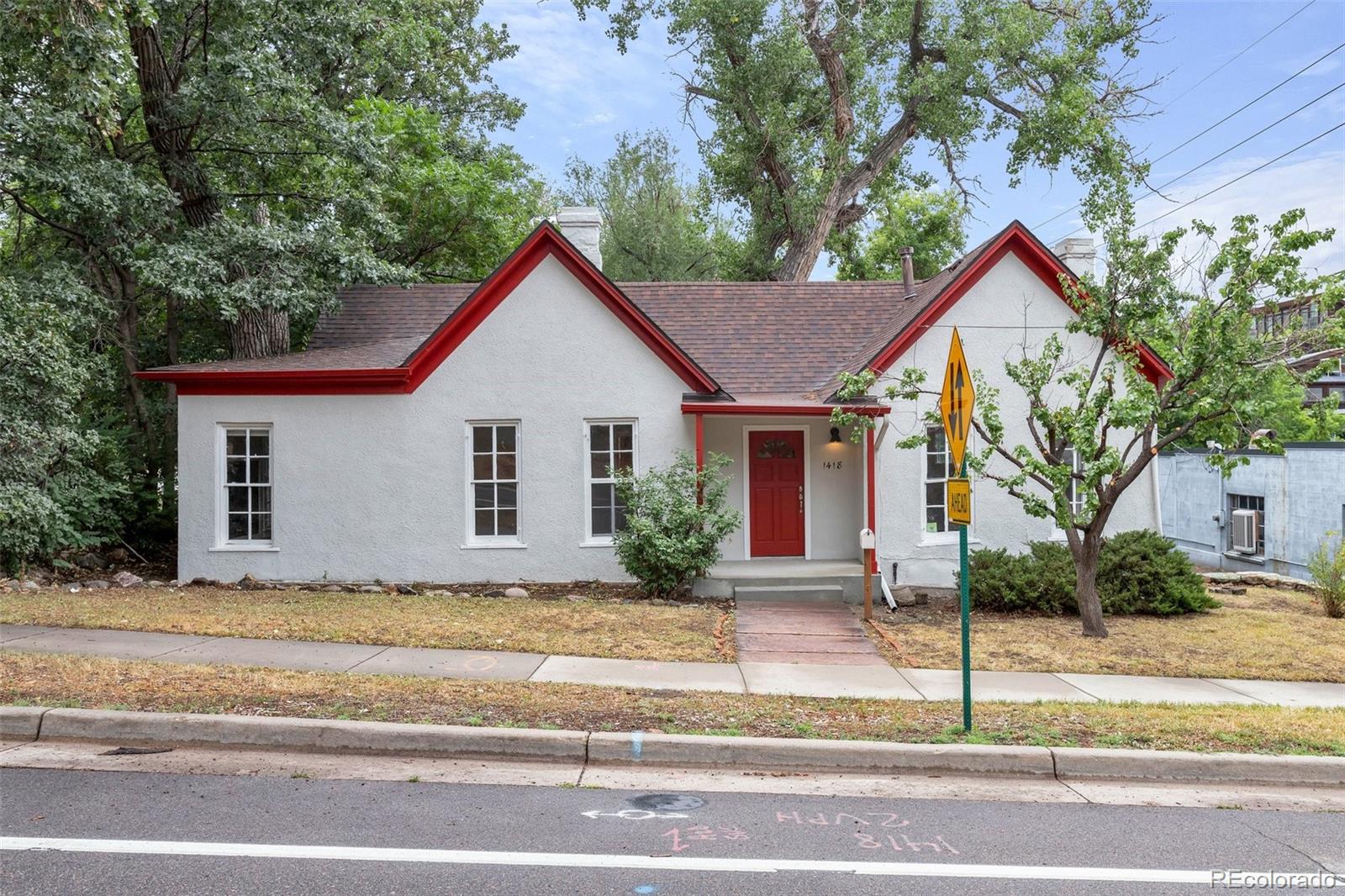 a view of house with a yard and large tree