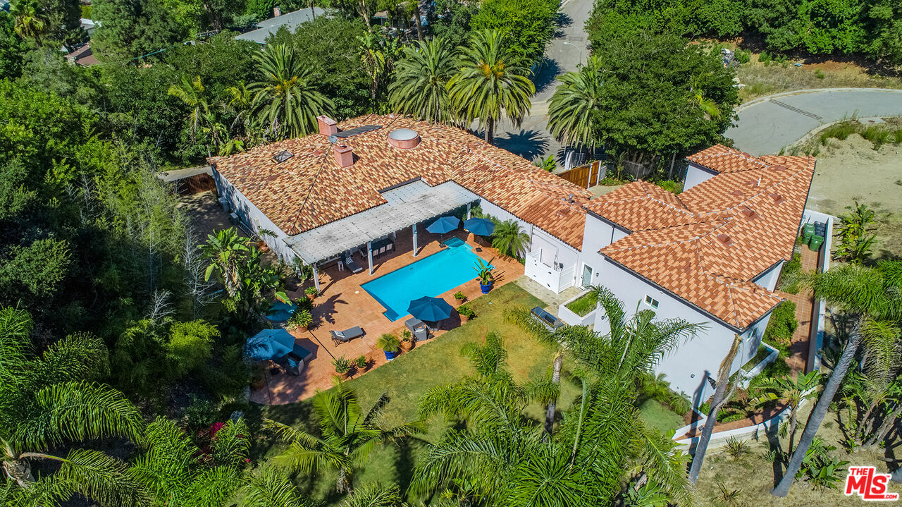 an aerial view of a house with a yard and swimming pool