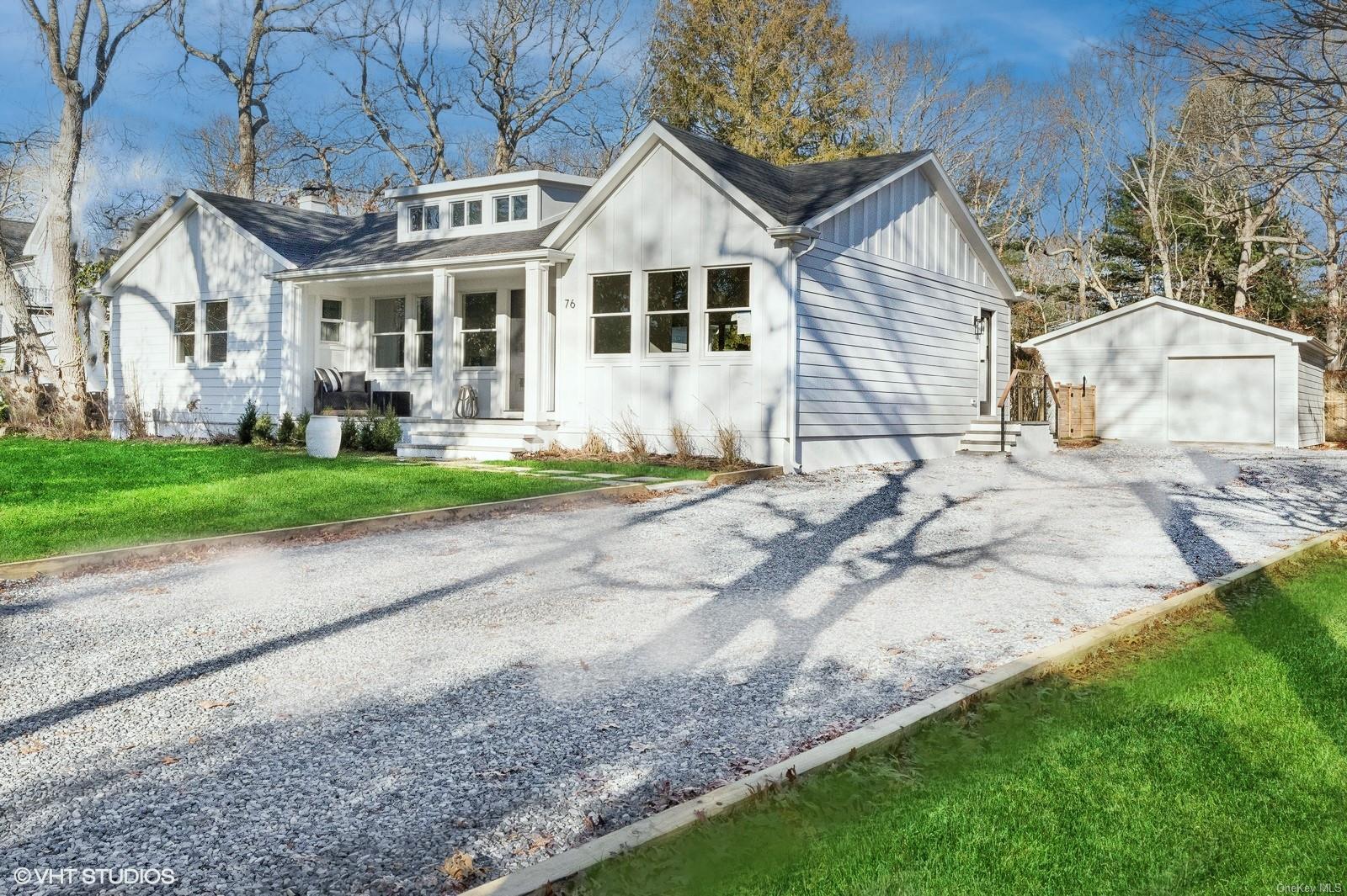 Modern inspired farmhouse with an outbuilding, a garage, a front lawn, and covered porch