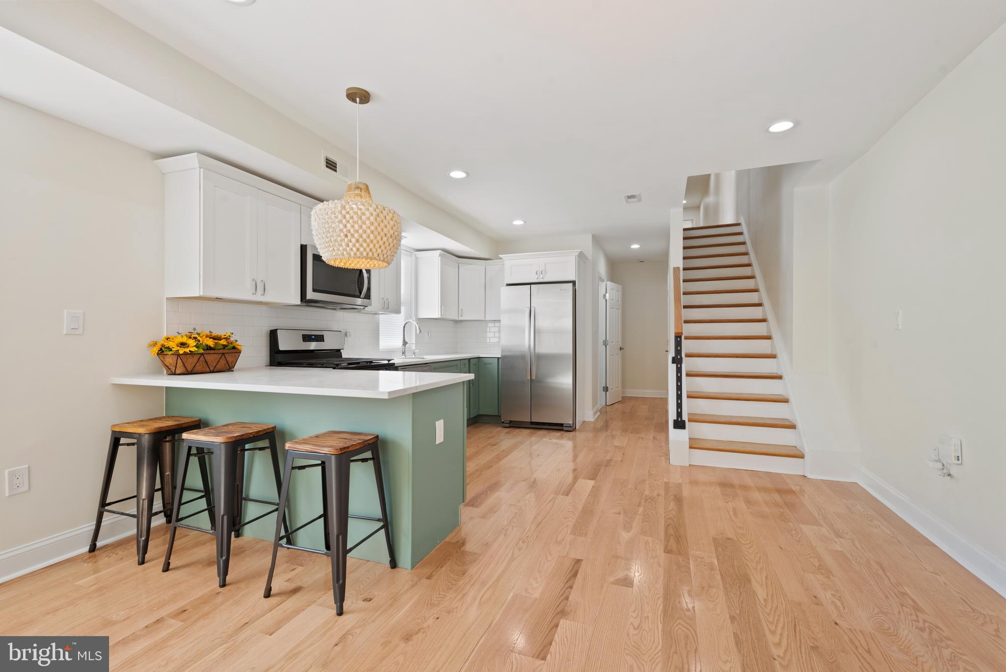 a kitchen with stainless steel appliances a white cabinets and wooden floor