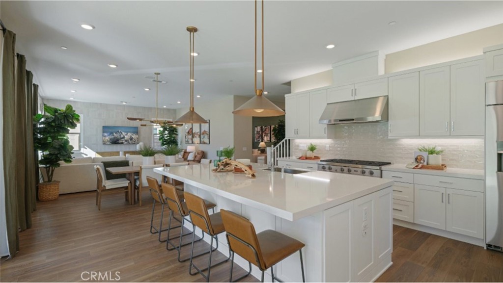 a large white kitchen with lots of counter space and stainless steel appliances