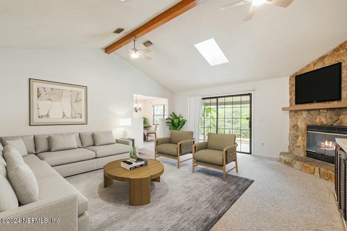 a living room with furniture a fireplace and a flat screen tv