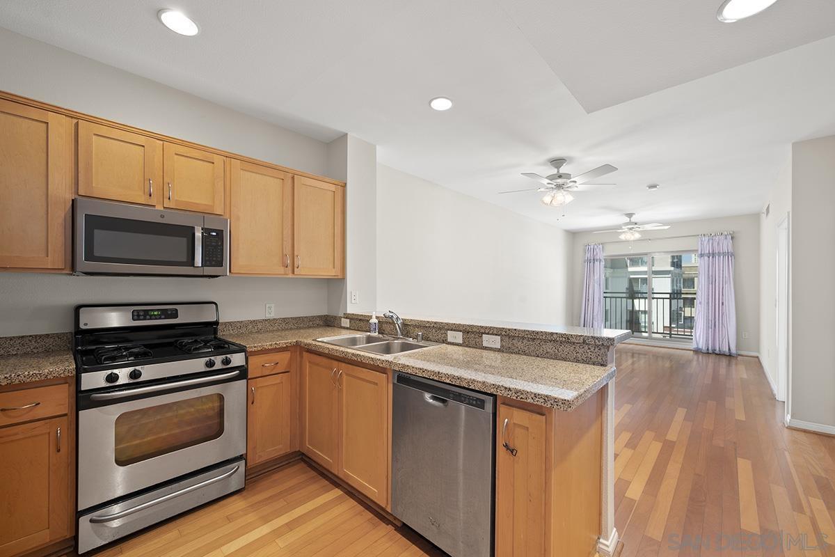 a kitchen with stainless steel appliances granite countertop a stove a sink and a microwave