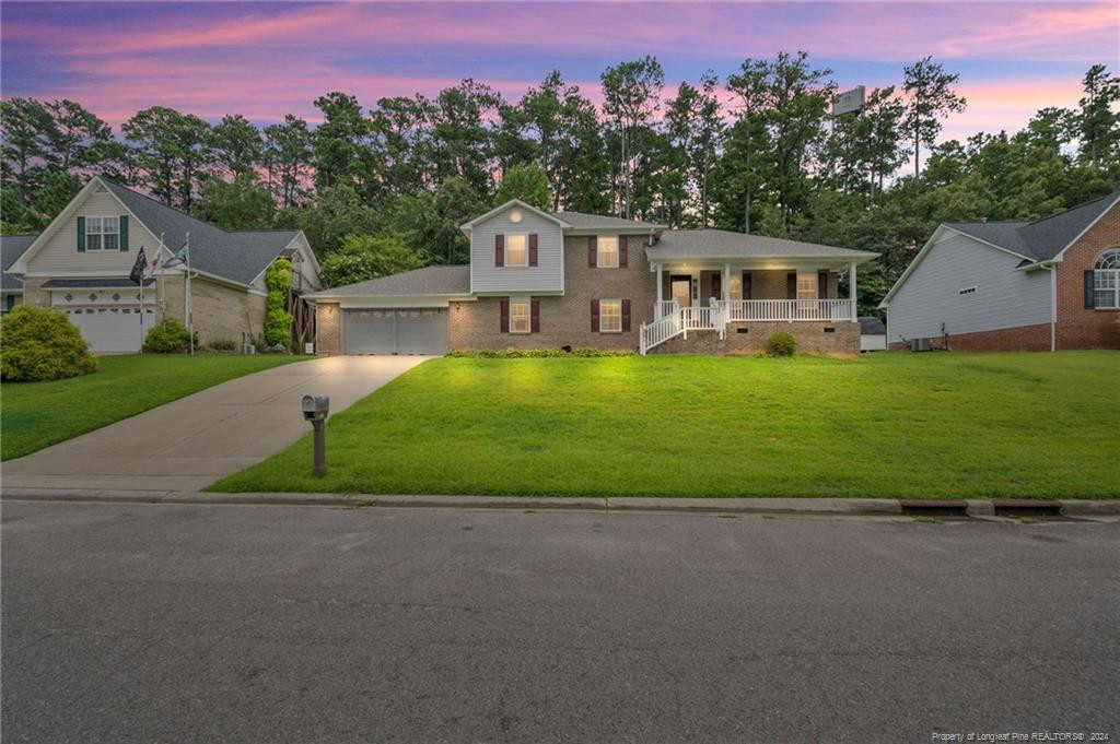 a front view of a house with a garden and trees