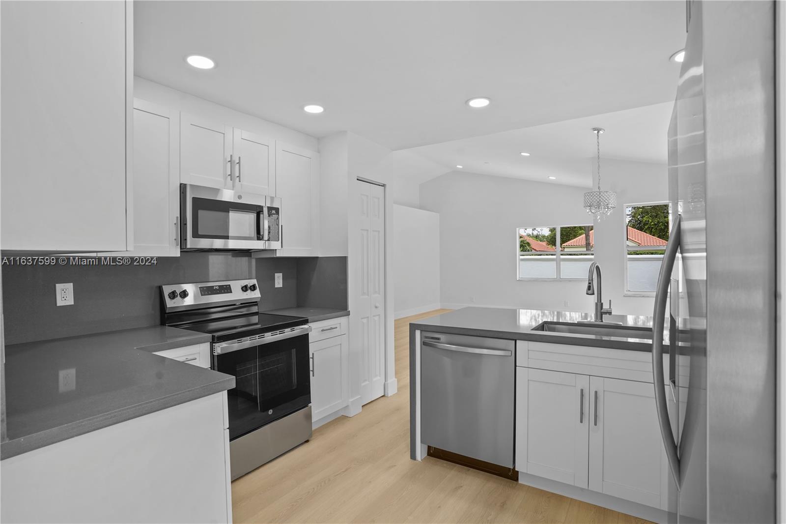 a kitchen with a sink stainless steel appliances and white cabinets