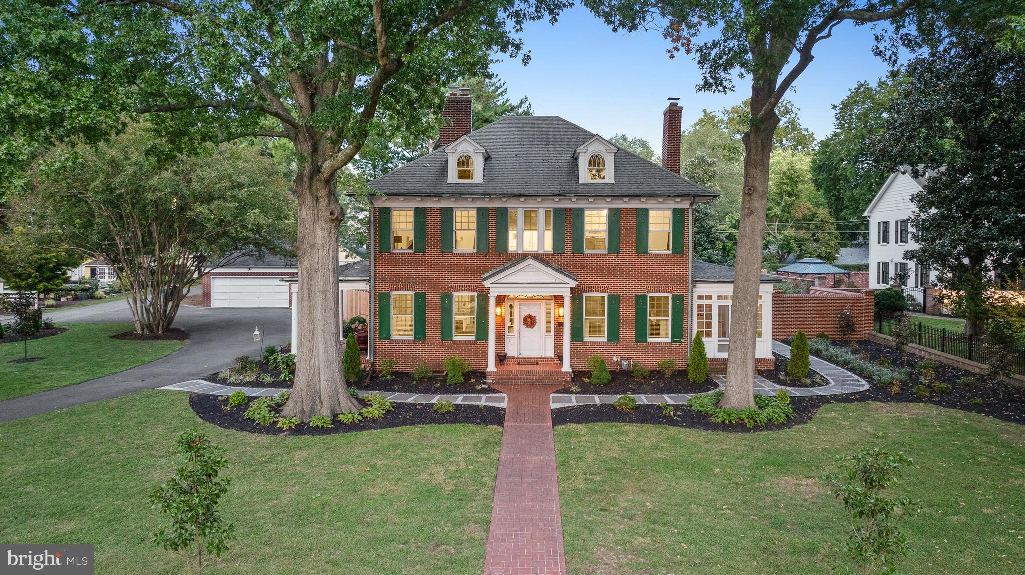 a front view of a house with a yard and trees