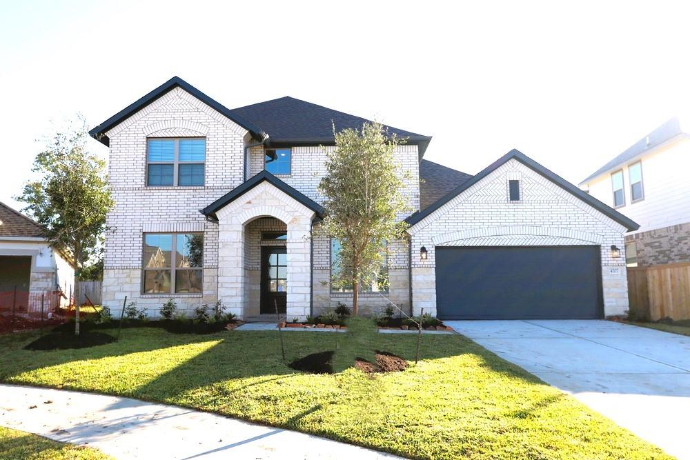 a front view of a house with yard and garage